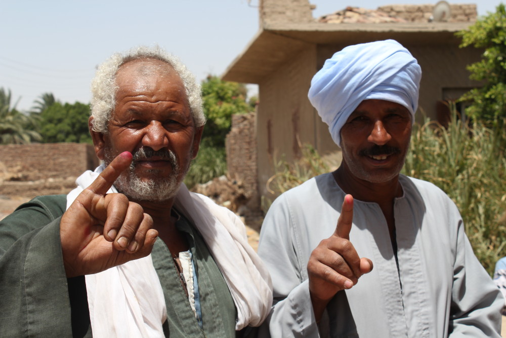 Voters in Abu Qlay'I show off their ink-stained fingers-1