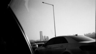 Black and white image of a car on the highway.